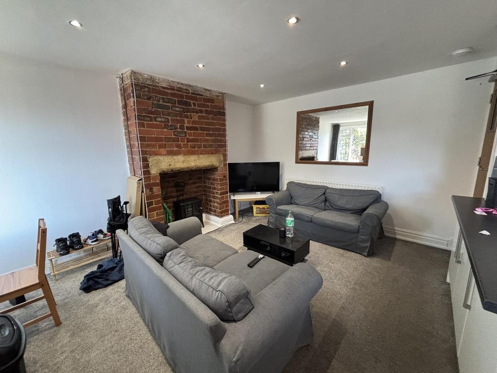 A spacious, well-lit living room featuring comf...