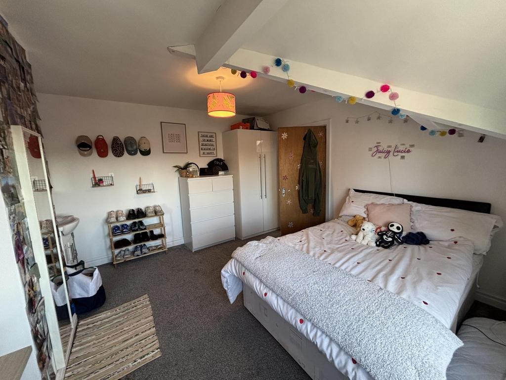 A bright and inviting bedroom featuring a comfo...
