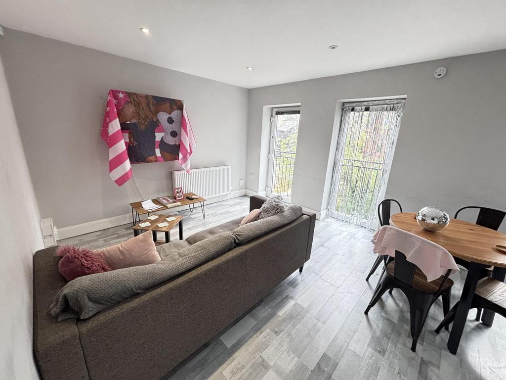 A spacious and well-lit living room featuring m...