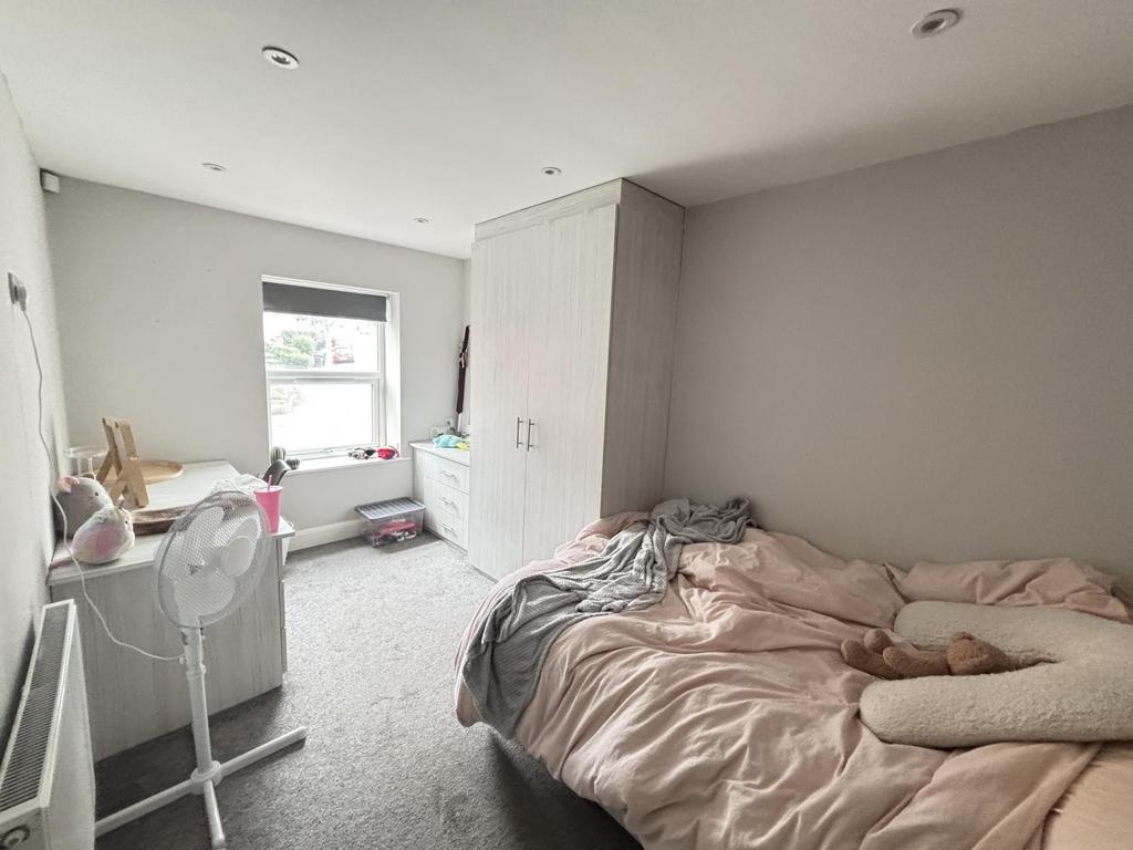 A bright and airy bedroom featuring a double be...