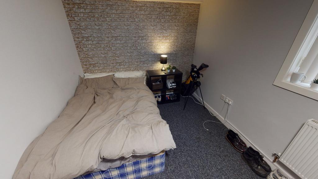 A modest bedroom with a double bed positioned a...
