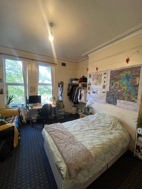A comfortable and well-lit double bedroom with ...