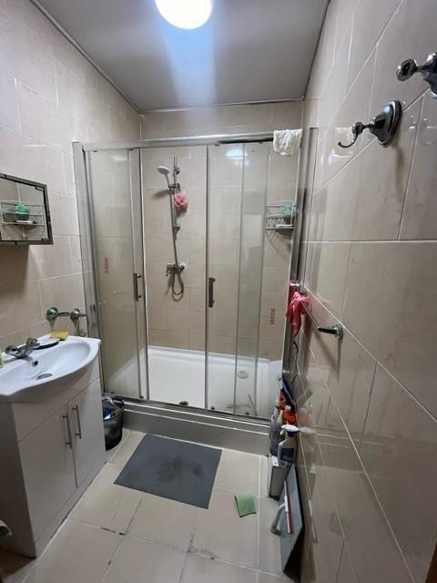 A modern bathroom featuring a glass-enclosed sh...