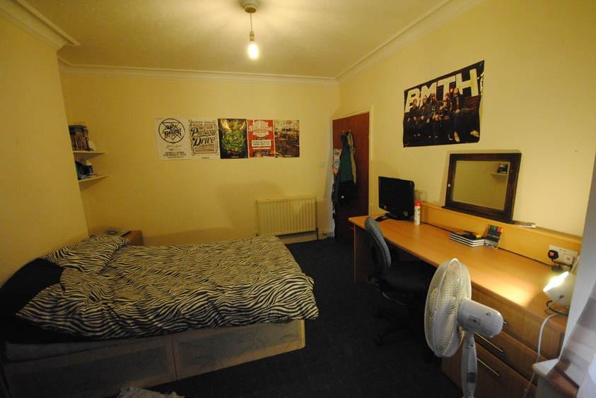 A cozy single bedroom featuring a comfortable b...