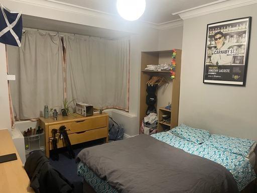 A cozy bedroom featuring a double bed, a study ...