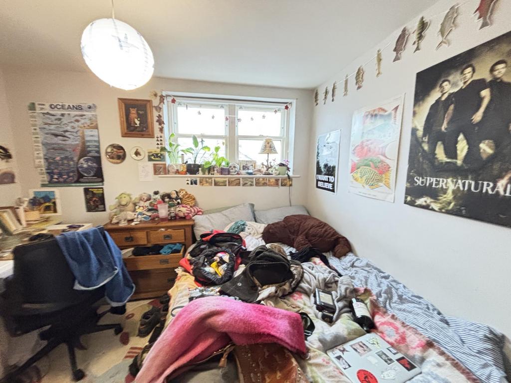 A cozy bedroom featuring a bed, desk, and perso...