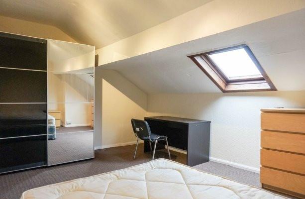 A bright and cozy bedroom with a skylight windo...