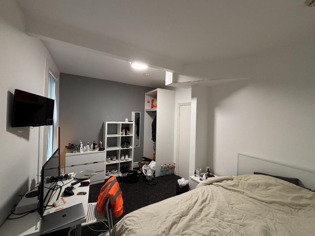 A cozy bedroom featuring a neatly made bed, a s...