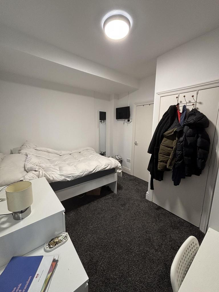 A tidy and comfortable student bedroom featurin...