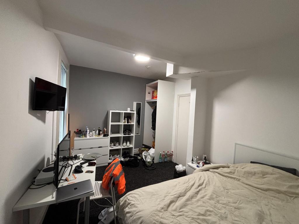 A cozy bedroom featuring a double bed with a wh...