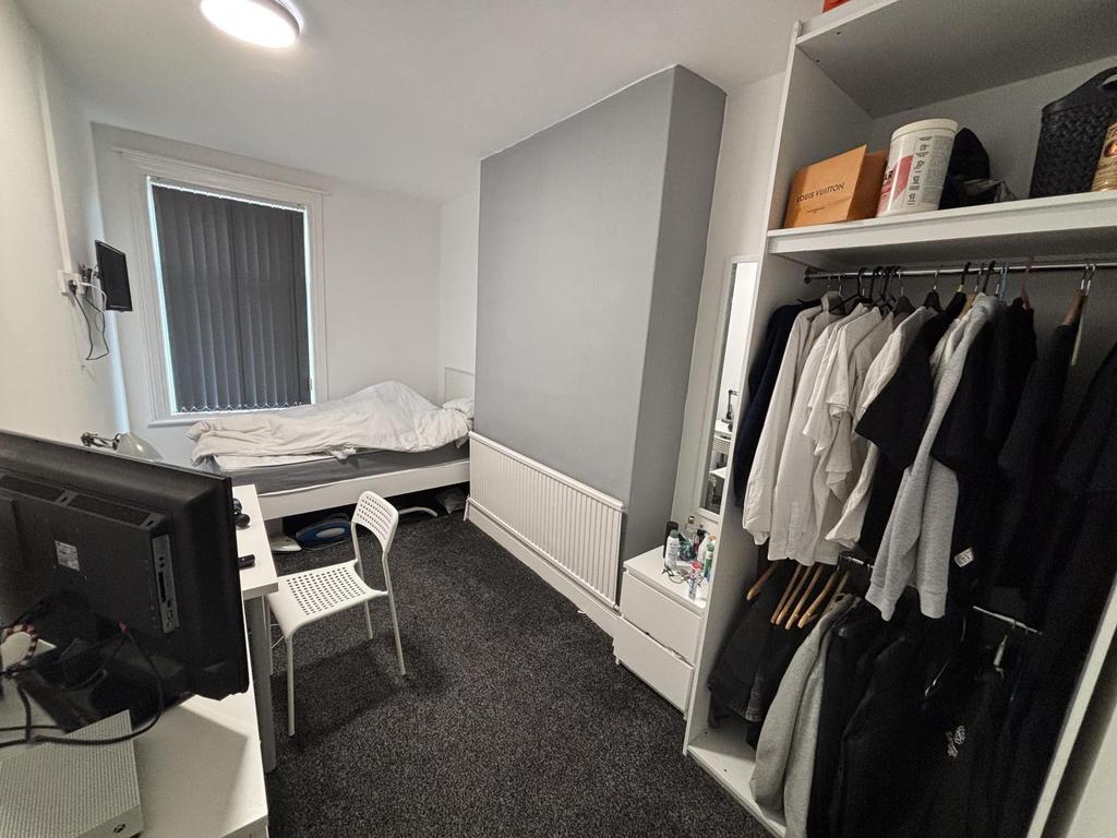 A neatly maintained single bedroom featuring a ...