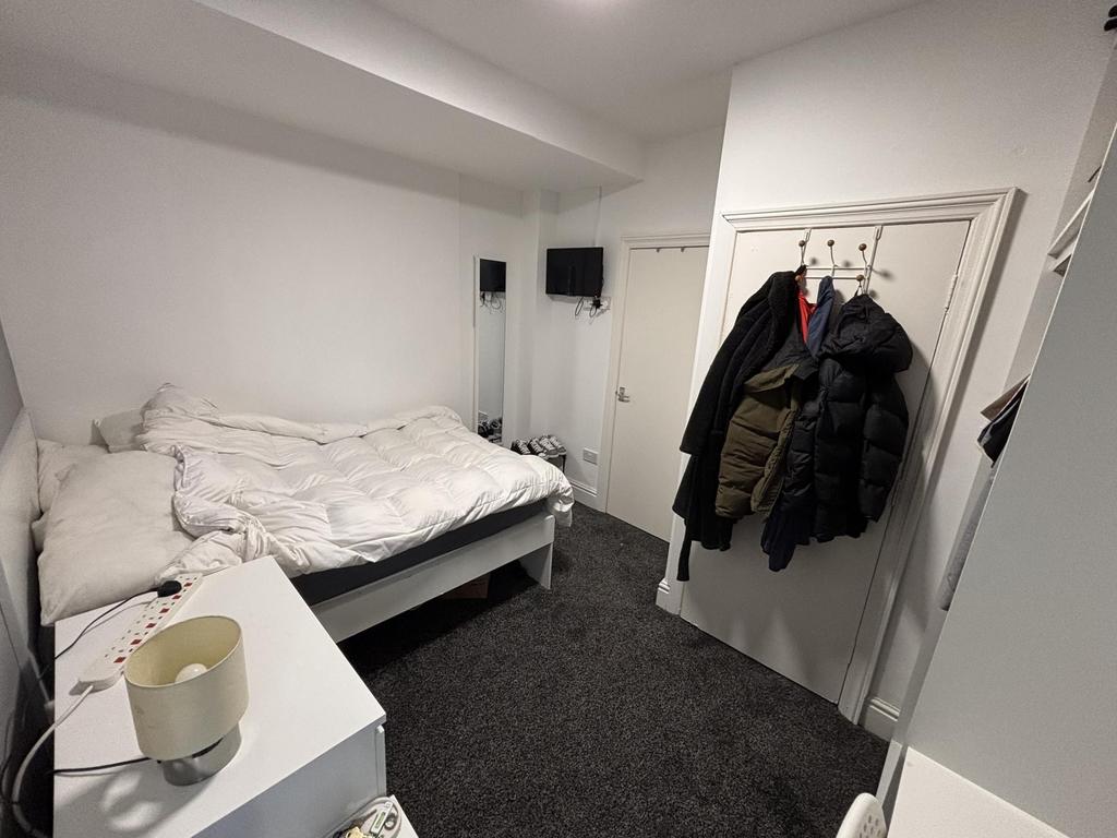 A cozy bedroom featuring a double bed with whit...