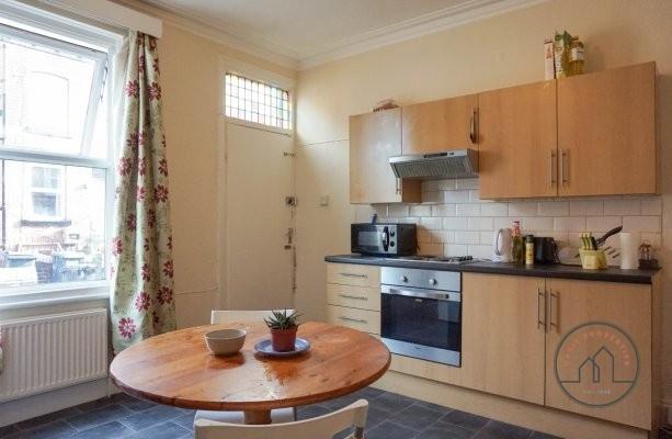 A cozy kitchen area featuring wooden cabinets, ...