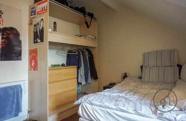 A cozy single bedroom featuring a neatly made b...