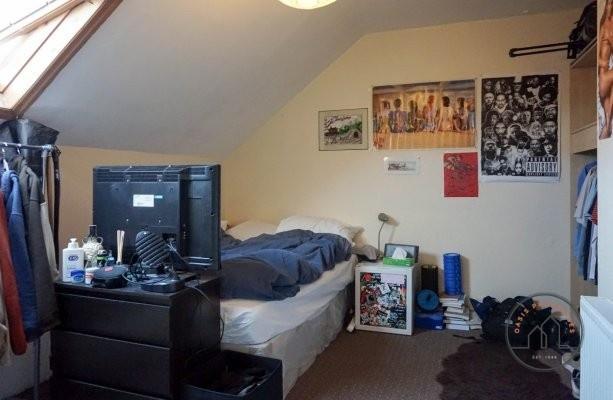 A cozy bedroom featuring a bed with storage, a ...