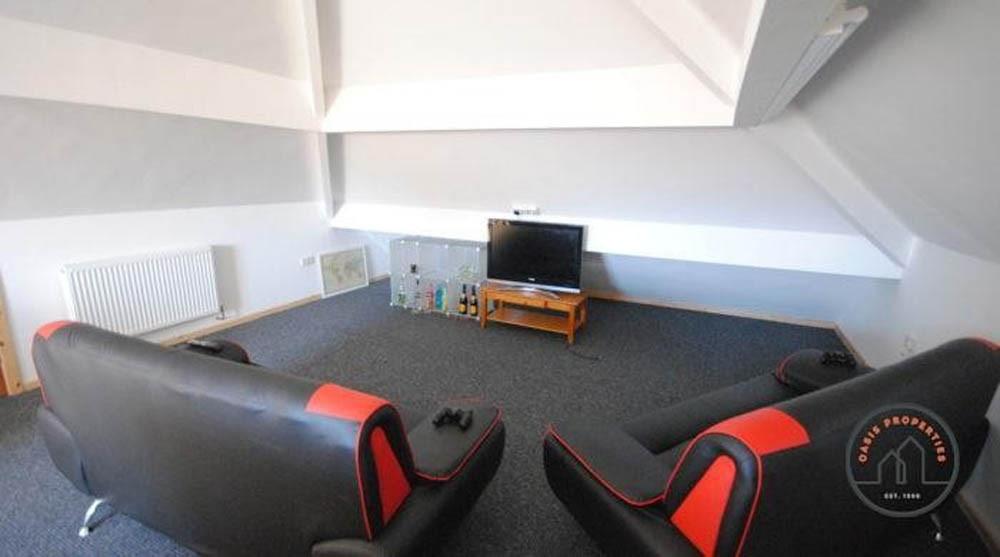A cozy cinema room equipped with comfortable se...