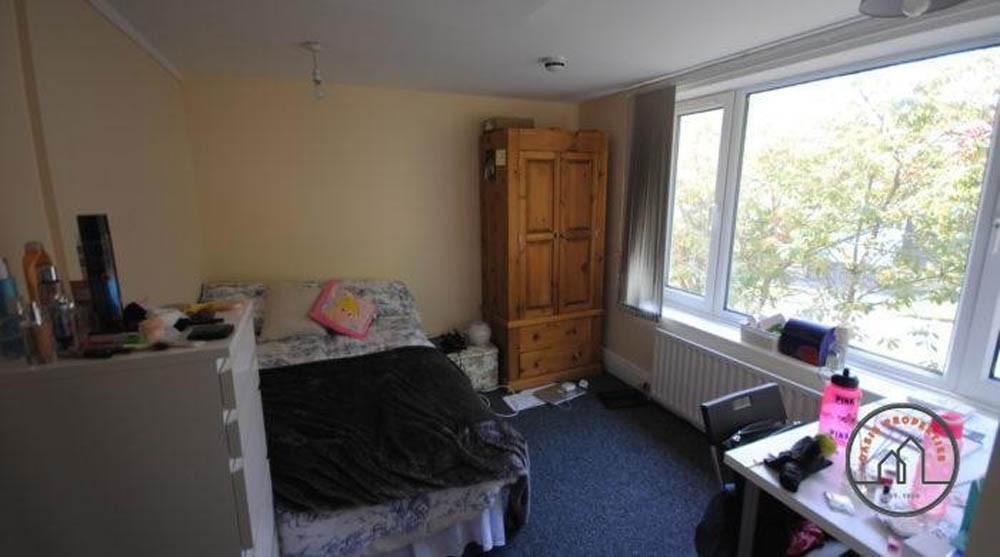 A cozy bedroom featuring a double bed, a wardro...