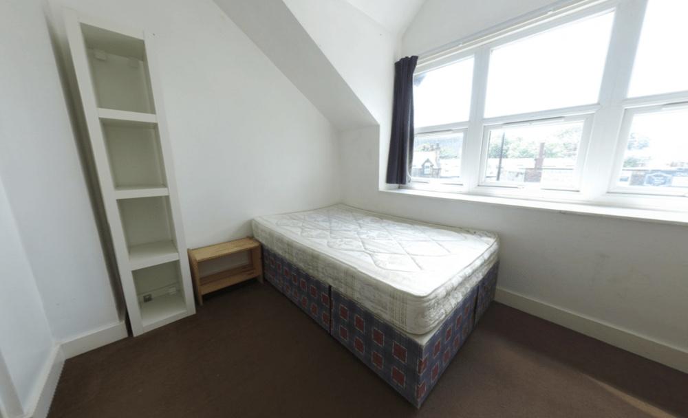 A cozy single bedroom with a comfortable bed po...