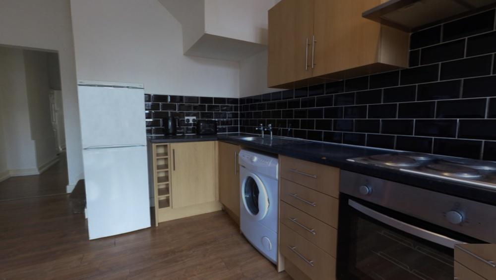 A modern kitchen area featuring wooden cabinets...