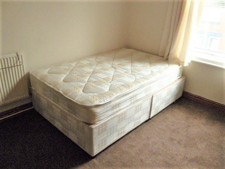A comfortable double bedroom featuring a large ...