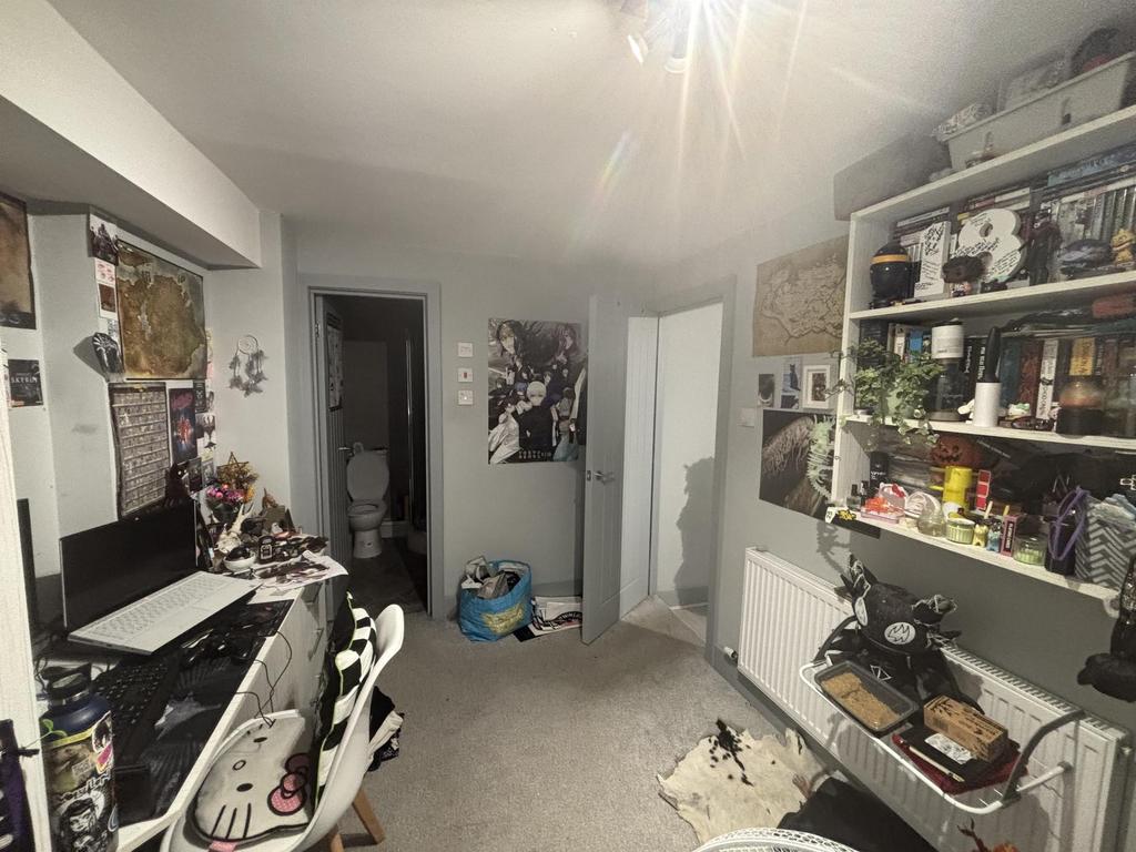 Well-appointed bedroom with a study area, shelv...