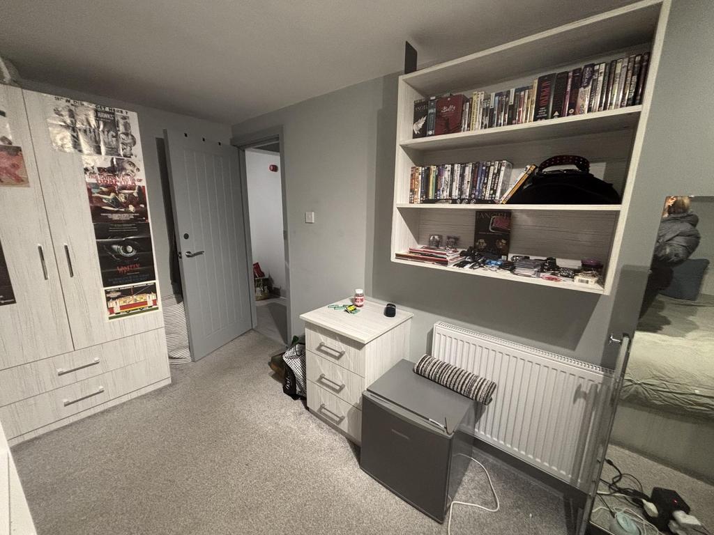A neatly organized bedroom with a comfortable b...