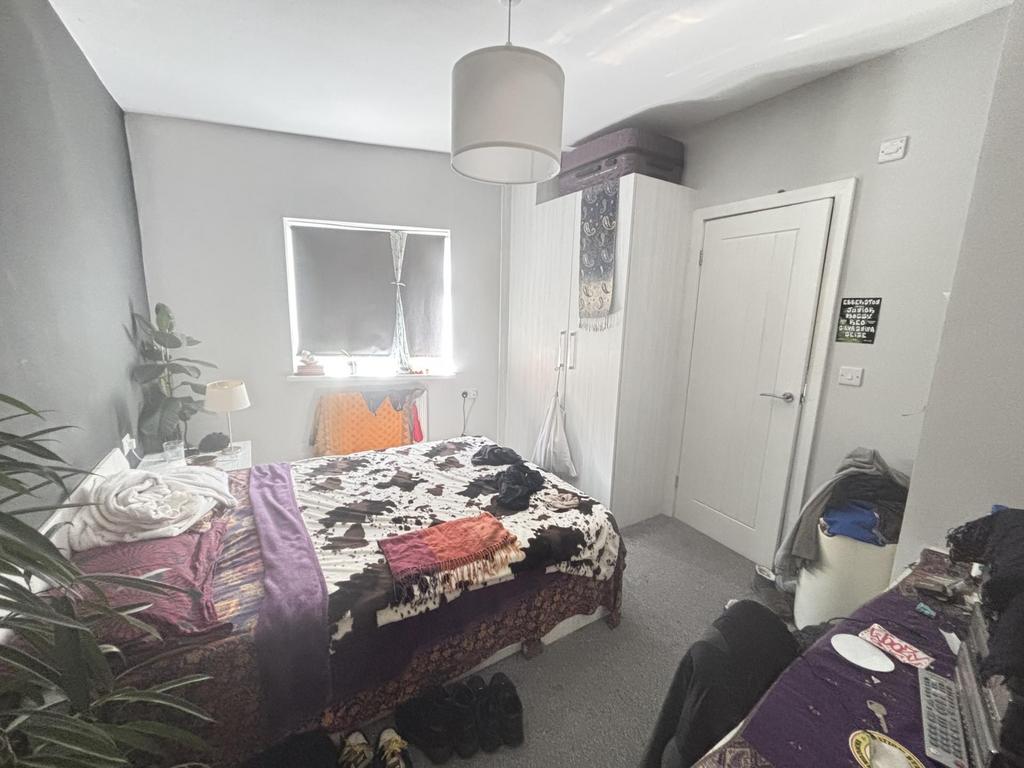 A cozy bedroom featuring a double bed with colo...