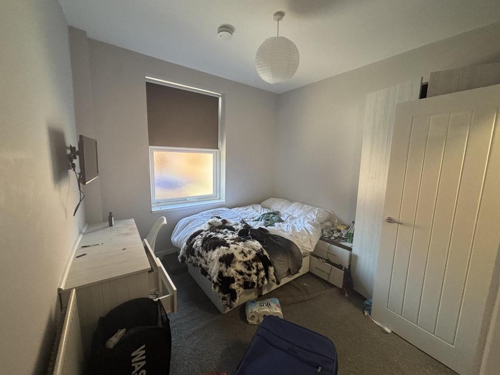 A spacious master bedroom featuring a large bed...