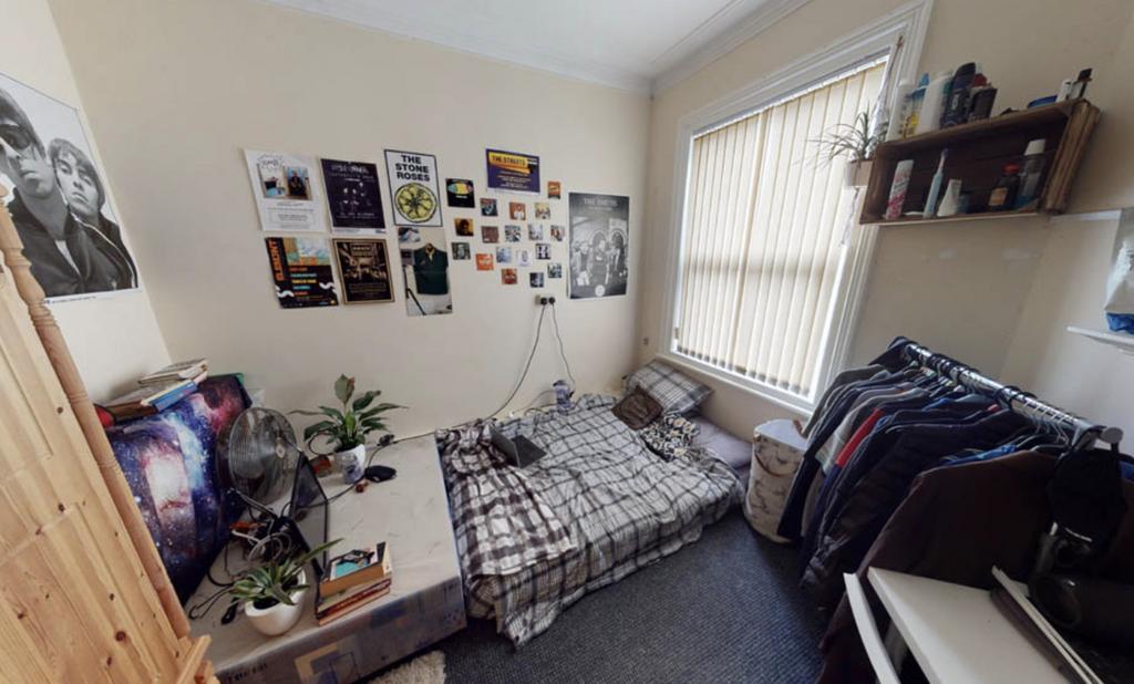 A cozy single bedroom featuring a bed with a ch...