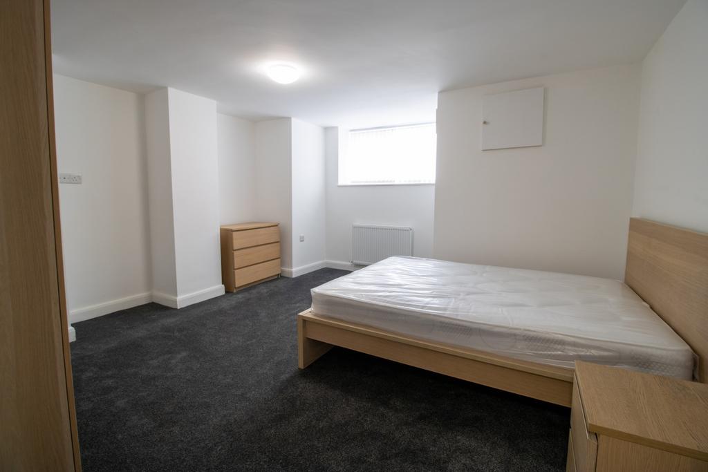 A bright, neatly maintained bedroom featuring a...