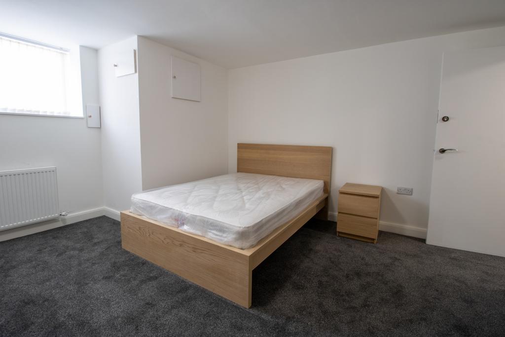 A tidy, well-lit bedroom featuring a double bed...