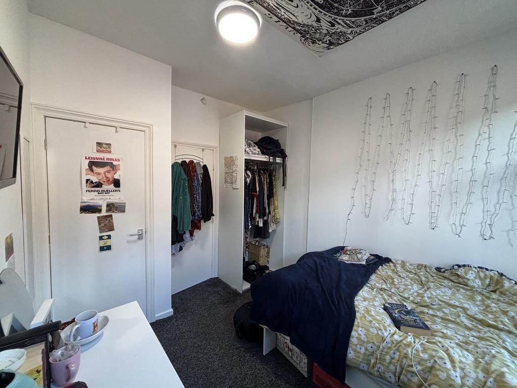 A cozy bedroom featuring a neatly made bed and ...