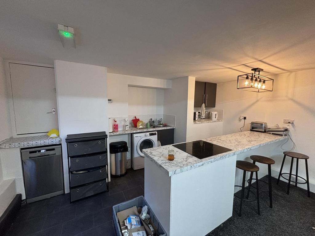 Contemporary kitchen area with a white countert...