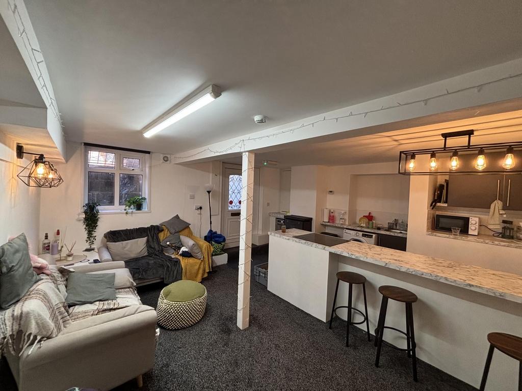 A spacious, well-lit living room featuring comf...
