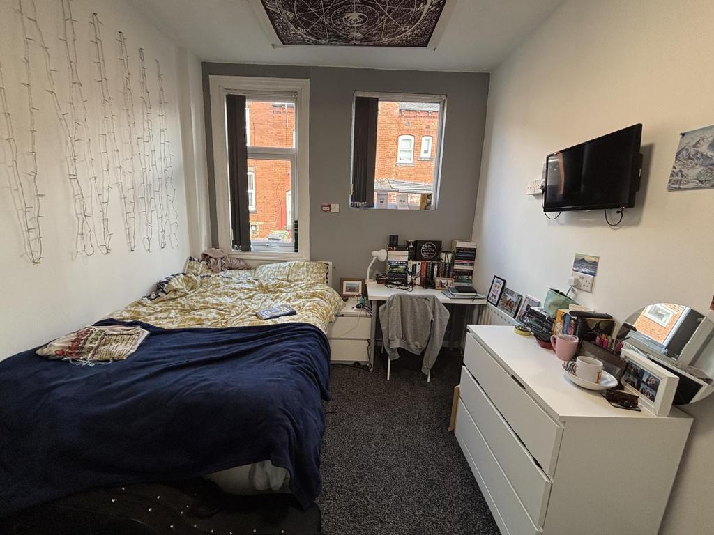 A cozy bedroom with a comfortable double bed, a...