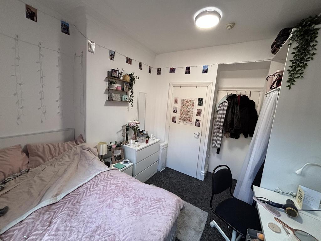 A cozy and well-maintained bedroom featuring a ...