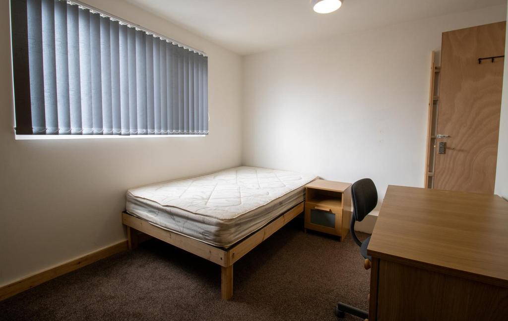 Neat, simply furnished bedroom with a single be...