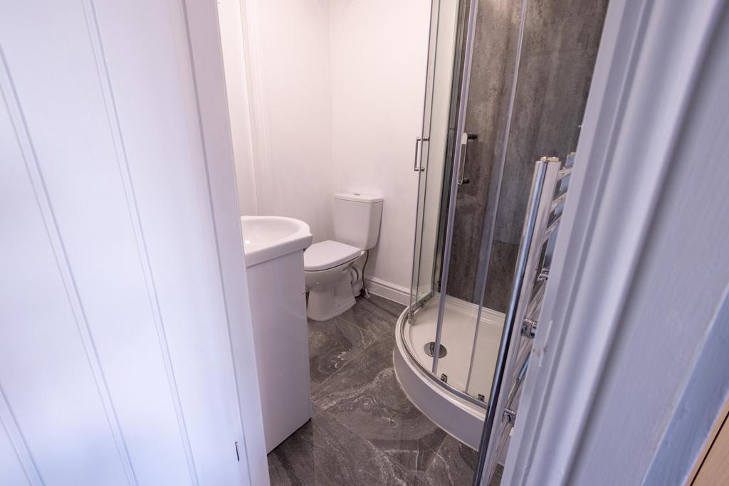 Bright, modern bathroom with a corner shower en...