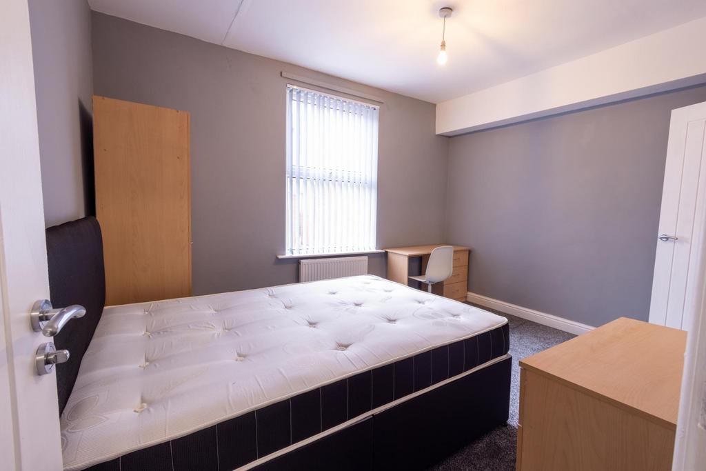 Bright, simply furnished bedroom with a comfort...
