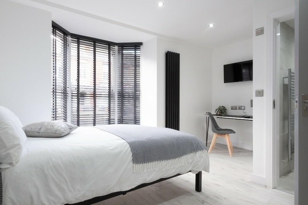 Bright and modern master bedroom featuring a co...