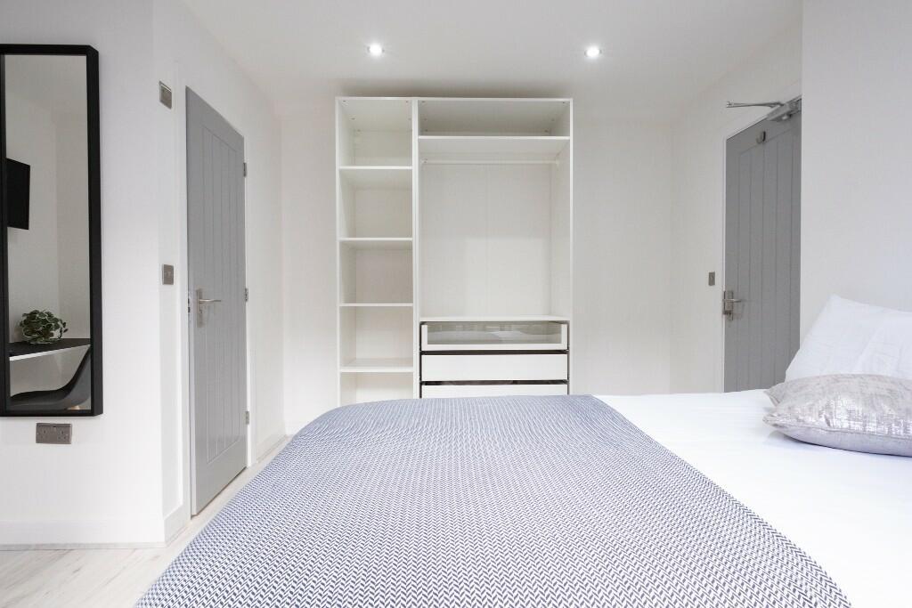 Bright and modern master bedroom featuring a co...