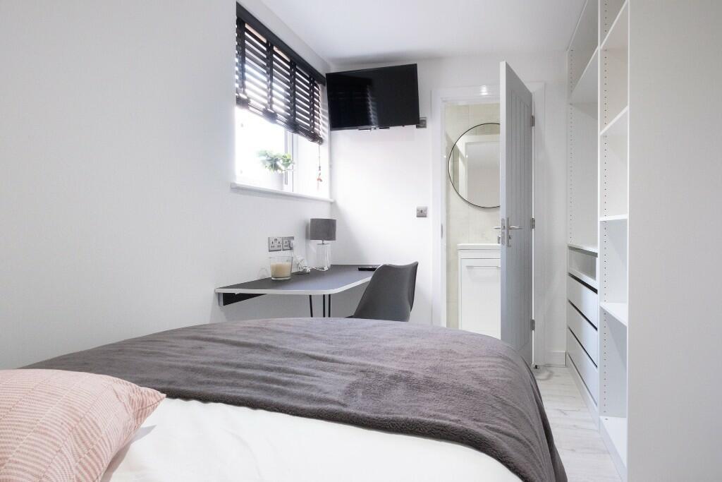 Bright and modern single bedroom featuring a co...