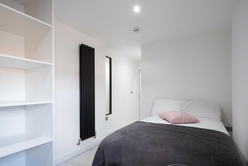 A bright and tidy single bedroom featuring a co...