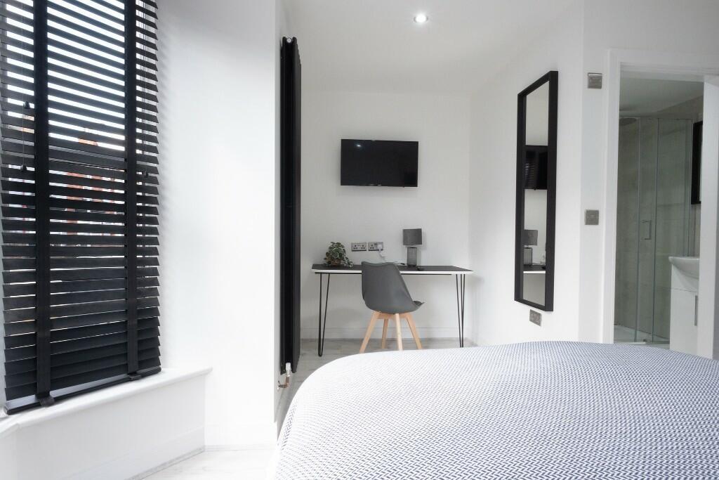 A bright and modern master bedroom featuring a ...