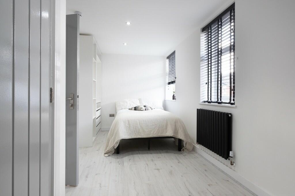 Bright and modern double bedroom featuring clea...