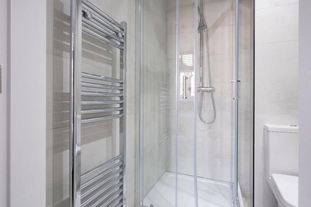 A modern bathroom suite featuring a clear glass...