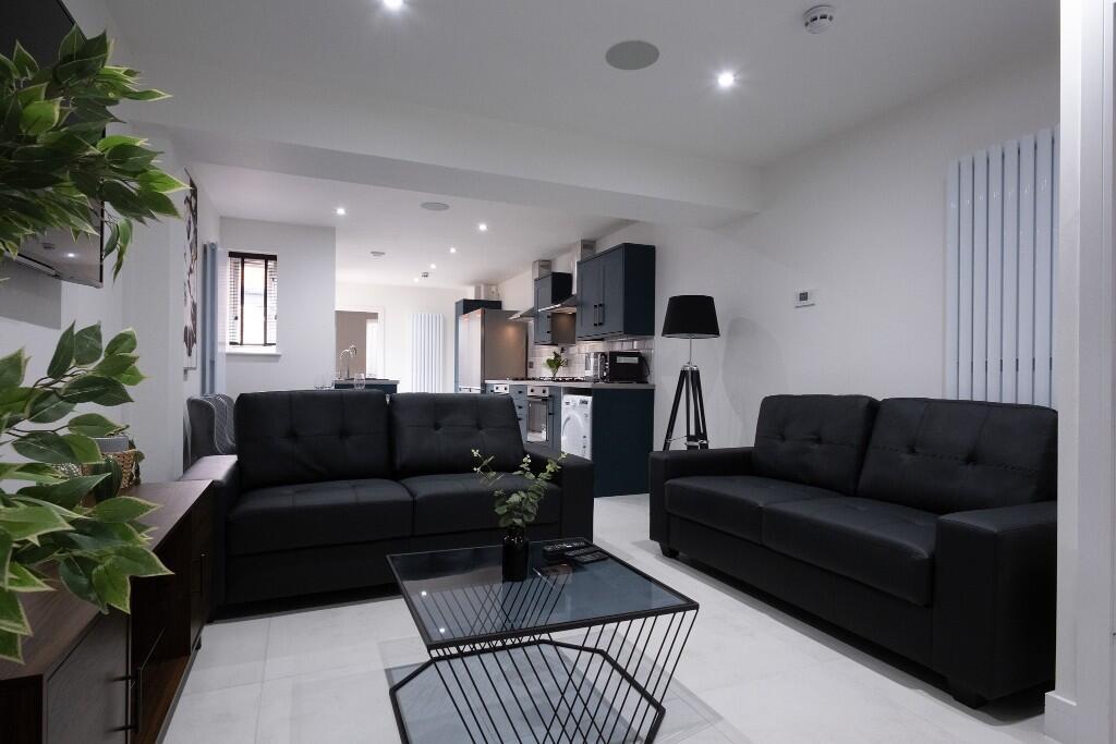 A stylish and contemporary living room featurin...
