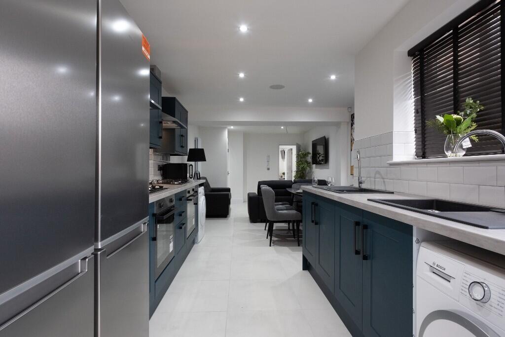 A modern kitchen featuring sleek cabinetry in a...