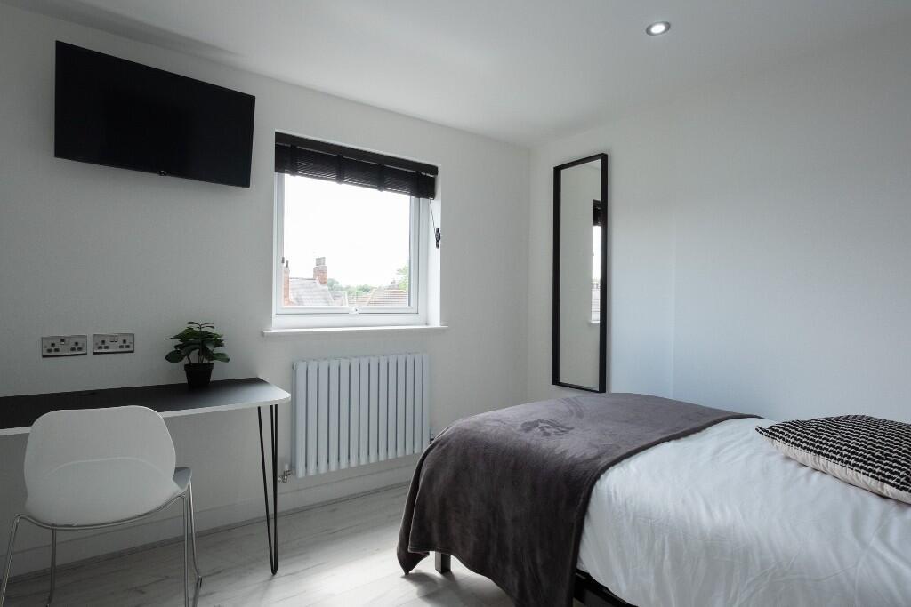 A bright and tidy single bedroom featuring a co...
