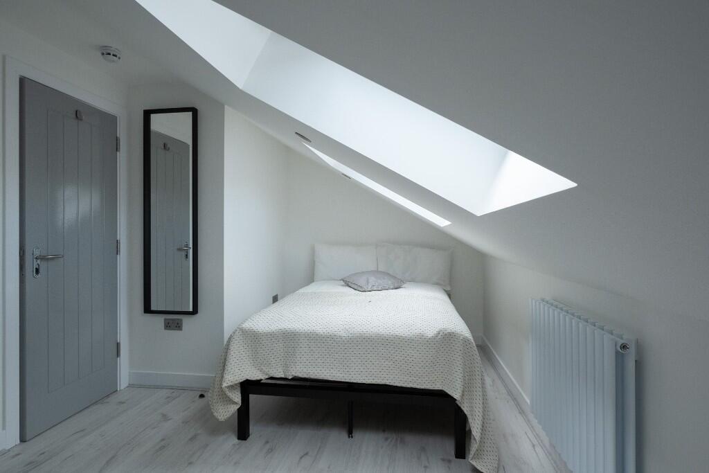 Bright and clean single bedroom with a neatly m...
